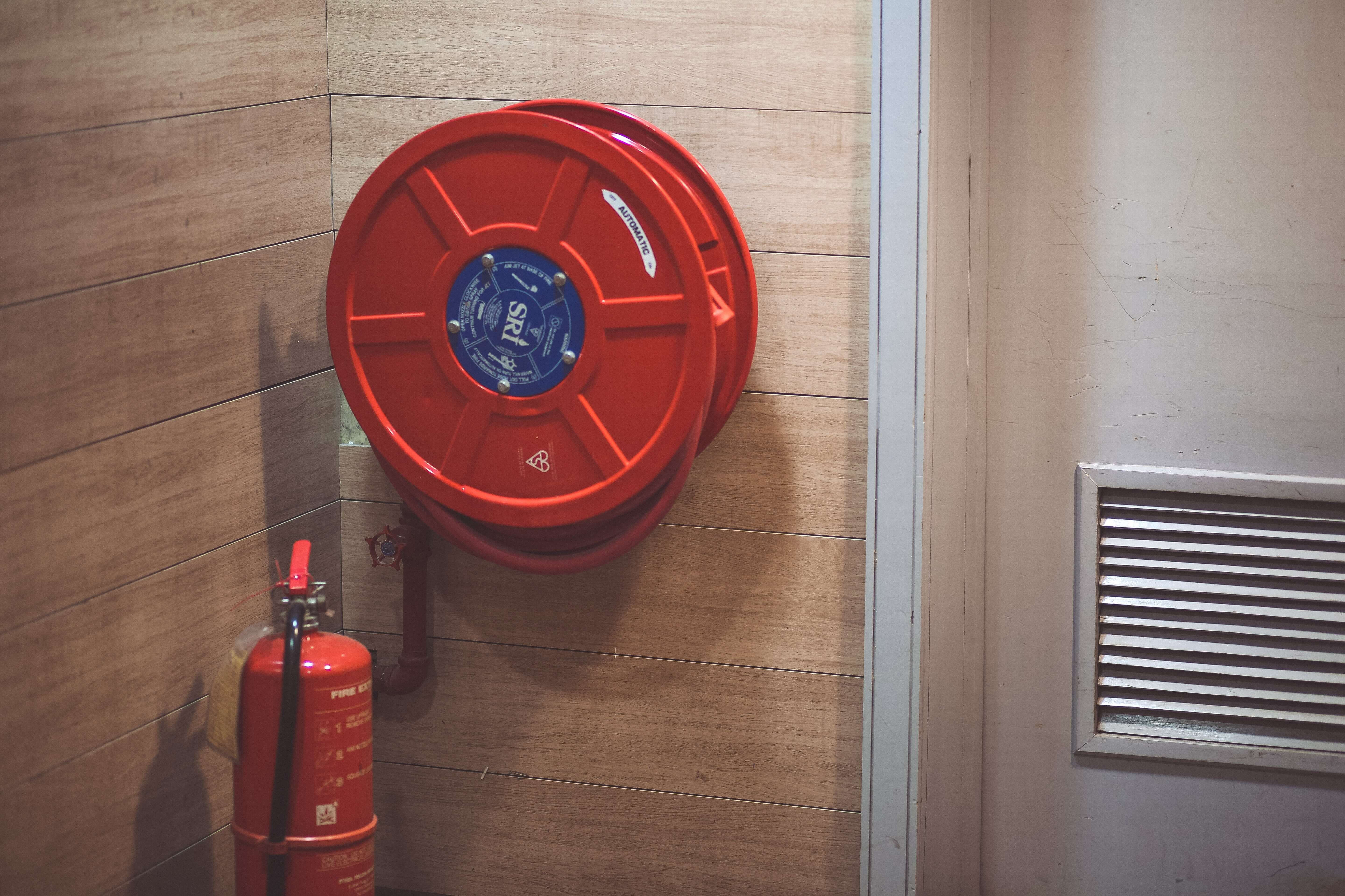 red-fire-extinguisher-beside-hose-reel-inside-the-room-189474 1